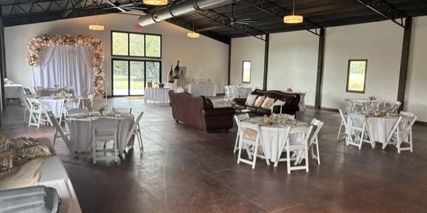 Spacious event hall with decorated tables and cozy seating.