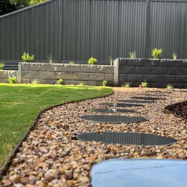 retaining wall, couch, turf laying, steel edging, turf, pebbles, bluestone, steppers, rusted steel