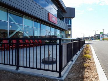 Installation de rampes en aluminium et en verre pour terrasses et balcons d’un immeuble commercial.