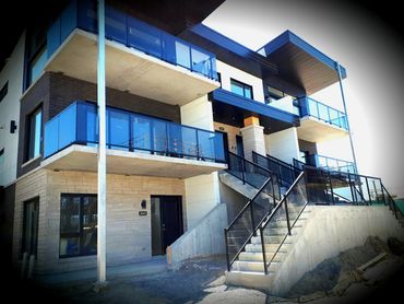 Installation de rampes en aluminium et en verre pour terrasses et balcons d’un immeuble commercial.