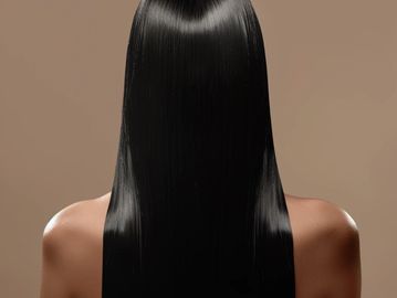 Back view of a person with long, sleek black hair.