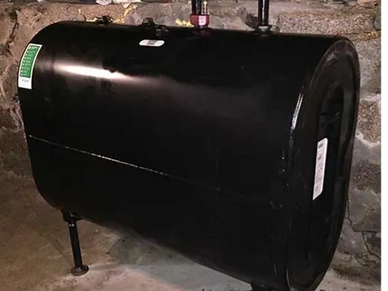 Black color oil tank placed beside wall