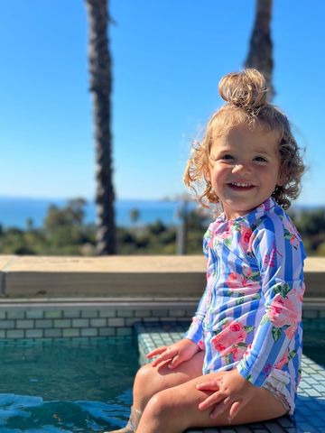 Girl smiling in a pool overlooking the ocean. Swim lessons Montecito. Private swim instructor 