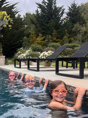 Three girls in goggles private swimming lessons with their private swim instructor water safe