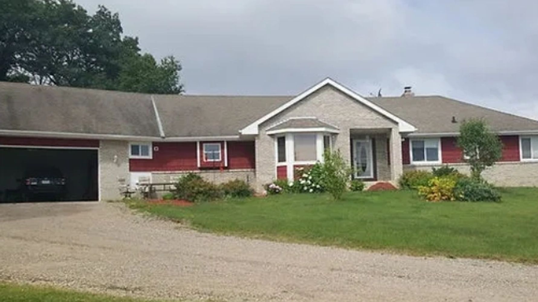 Single-story suburban house with red and beige siding and a garage.