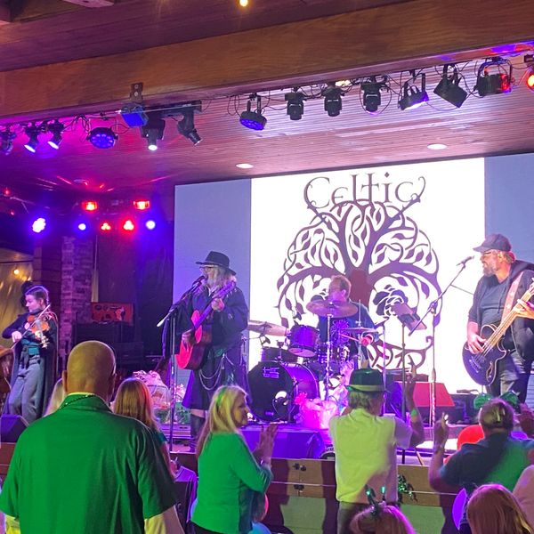 A live Celtic band performs on stage with an enthusiastic audience.