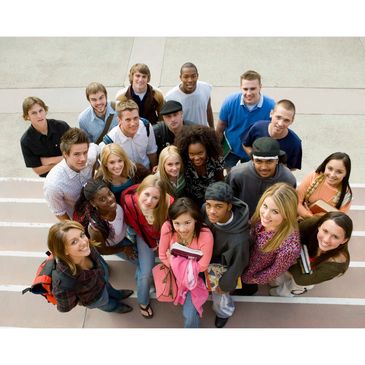 A diverse group of young adults standing together, looking up and smiling.