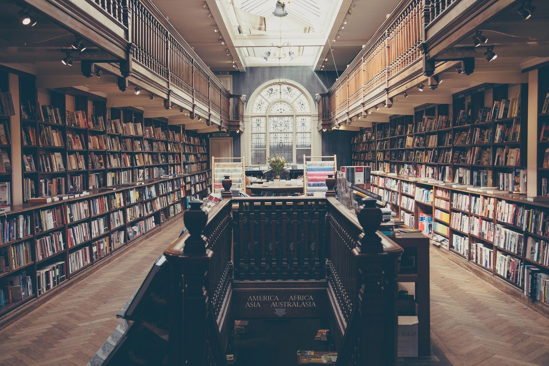 A vintage library interior with wooden shelves and a skylight.