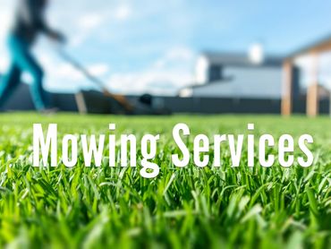 Close-up of green grass with blurred person mowing lawn and text 'Mowing Services'.