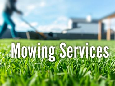 Close-up of green grass with blurred person mowing lawn and text 'Mowing Services'.