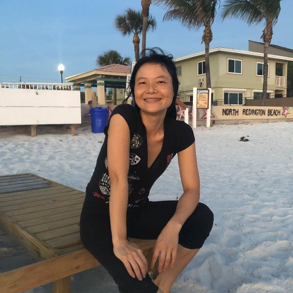 Woman smiling on a beach bench at North Redington Beach.