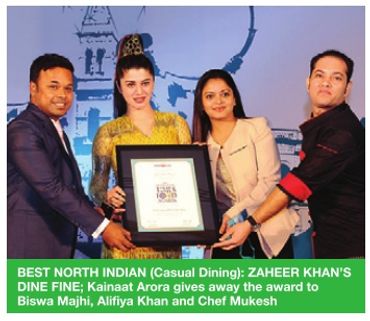 Four people presenting an award at a formal event.