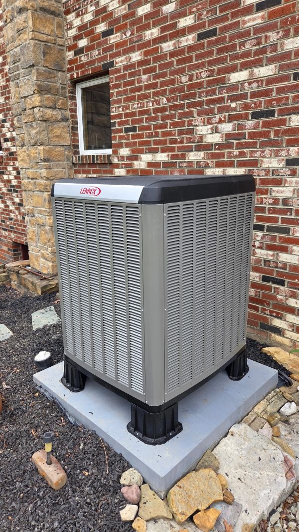 Outdoor Lennox air conditioning unit installed outside a brick house.