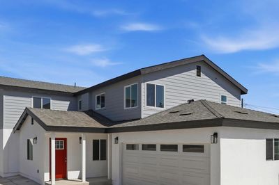 Two-story white house with a red front door and attached garage