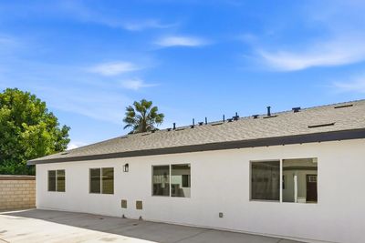 Single-story white house with a large concrete lot