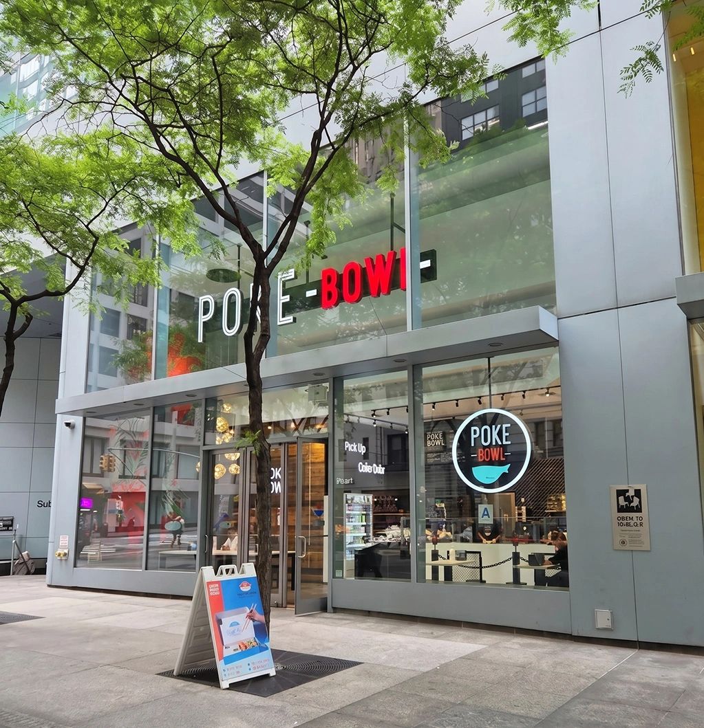 Modern Poke Bowl restaurant entrance with glass facade and outdoor sign.