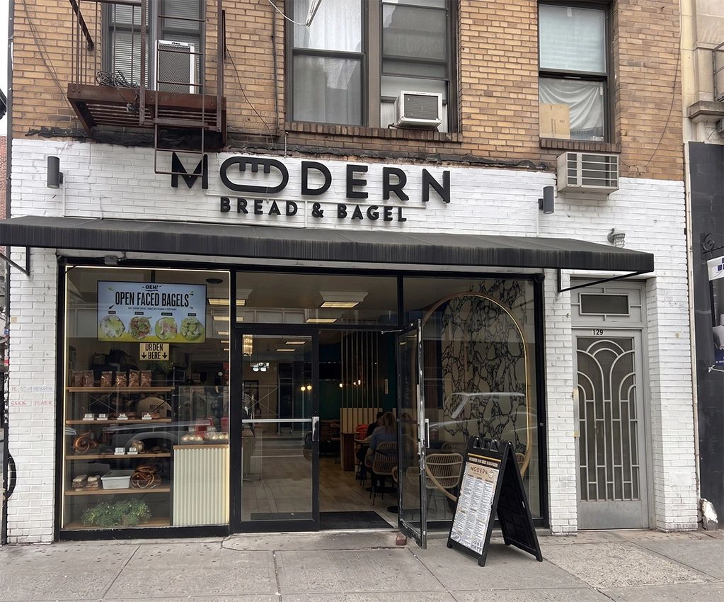 Modern Bread &amp; Bagel storefront with open glass doors and menu board outside.