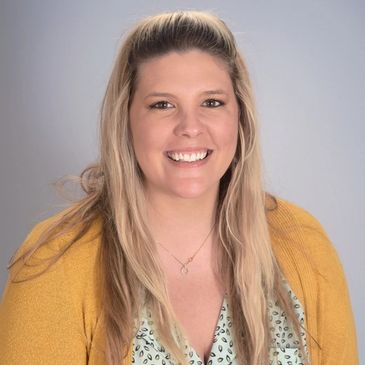 Headshot of a blond woman in a yellow cardigan