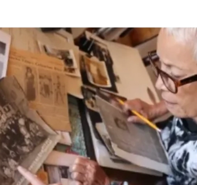 Herlinda Wong Chew's granddaughter Linda Yee Chew looking into family photoes