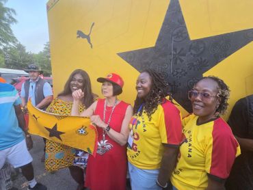 Group of fans posing with a Ghana flag.