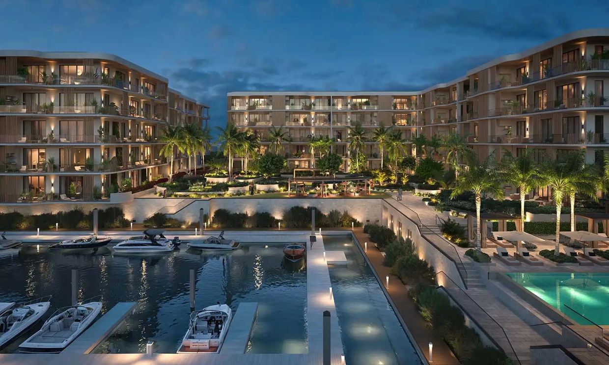 Luxury waterfront apartments with a marina and pool at dusk.