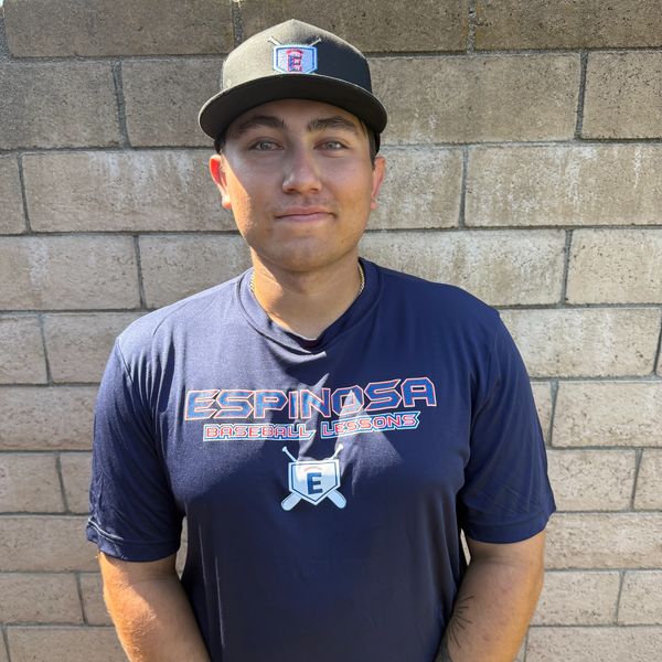 Young man wearing a baseball cap and Espinosa Baseball Lessons shirt.