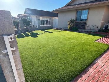 Well-maintained front yard with green lawn and brick walkway.
