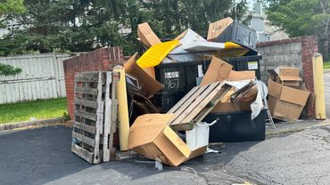 A commercial dumpster overflowing with trash