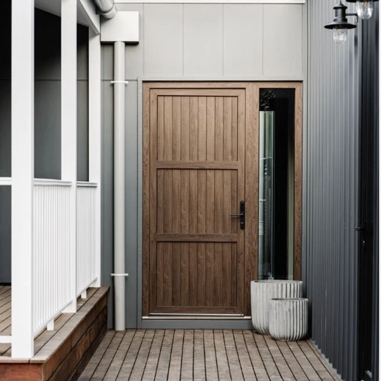 Minimalist porch with wooden door and vertical siding walls.