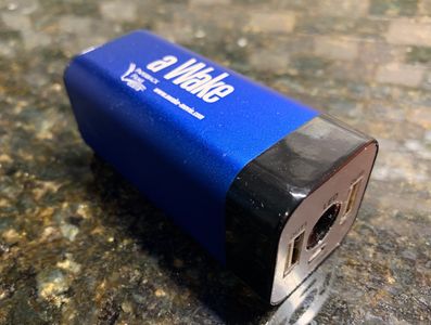 Portable blue electronic device with USB ports on a granite countertop.