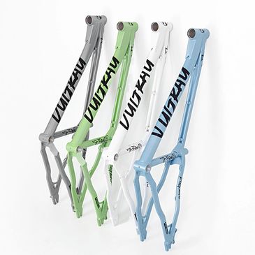 Four colorful bicycle frames in gray, green, white, and blue with bold branding.