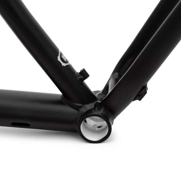 Close-up of a black bicycle frame bottom bracket shell and welds.