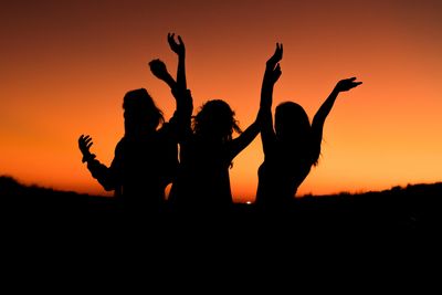 Silhouette of three women at sunset