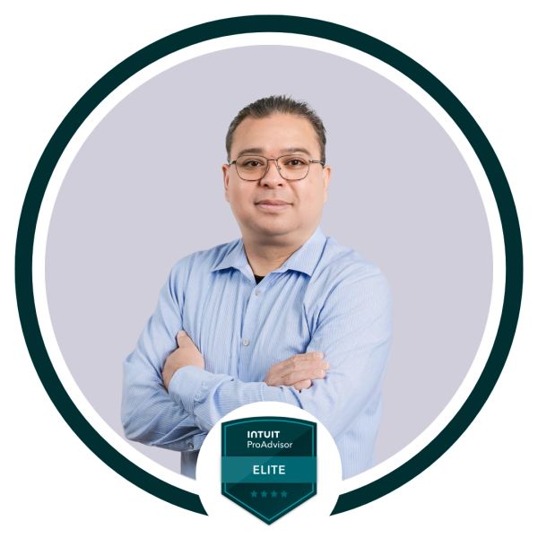 Professional portrait of a confident man wearing glasses and a blue shirt with an Intuit ProAdvisor Elite badge.