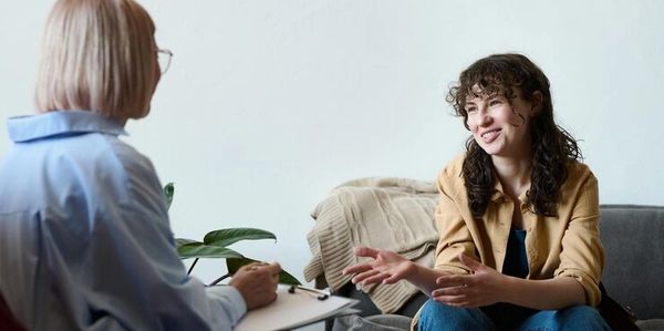 Smiling woman talking to a therapist during a therapy session.