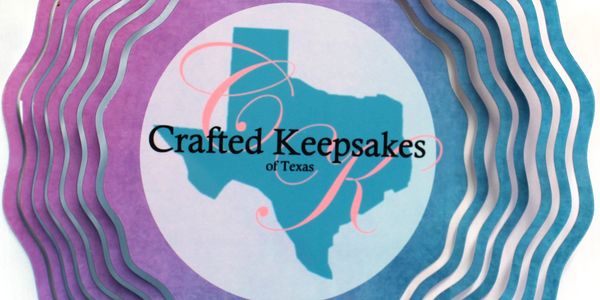 A decorative wind spinner featuring the Texas state silhouette and 'Crafted Keepsakes of Texas' text.