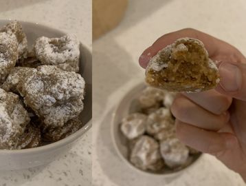 Powdered sugar cookies with a soft, spiced interior in a white bowl.