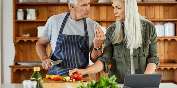 Mature couple cooking together in a cozy kitchen.