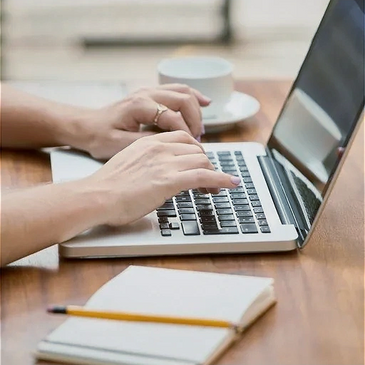 A woman typing on a laptop keyboard symbolizes business communications.