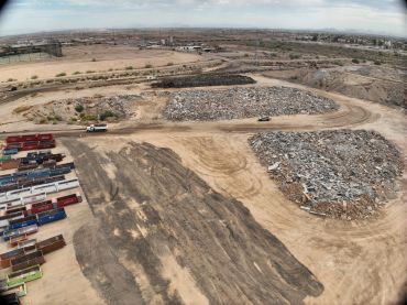 Aerial drone view of Phoenix material yard with concrete debris piles, containers, and active site t