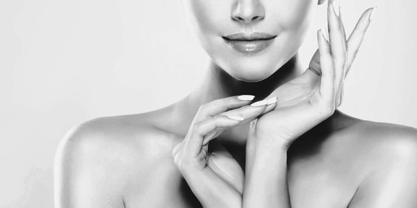 Elegant black and white close-up of a woman's face and hands.