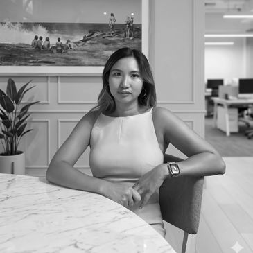 Professional woman seated at a marble table in an office.