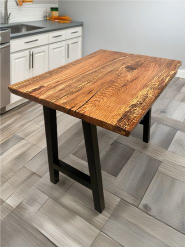 Rustic wooden table with black metal legs in a modern kitchen.