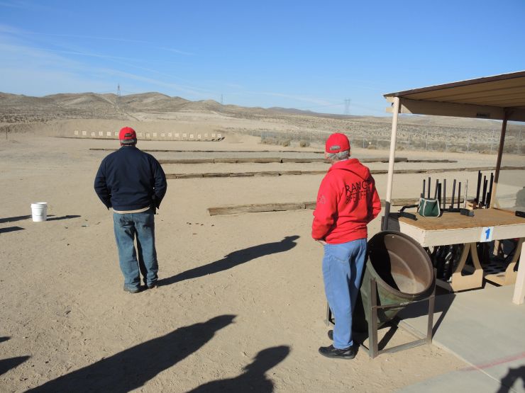 Two men stand at an outdoor shooting range in Adelanto, California
