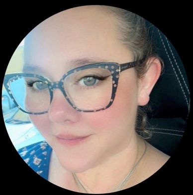 Close-up portrait of a woman with glasses and light makeup.