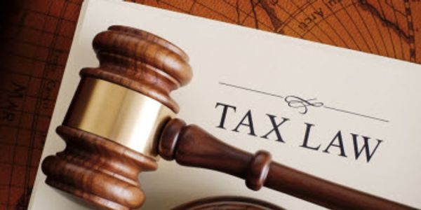 A judge's gavel resting on a document titled 'Tax Law'.