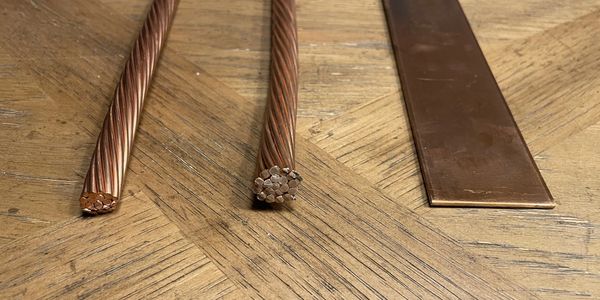 Two copper cables and a composite strip showing differences in surface area.