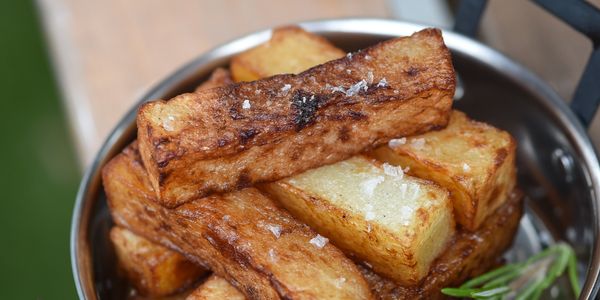 Golden crispy fries sprinkled with sea salt and garnished with rosemary.