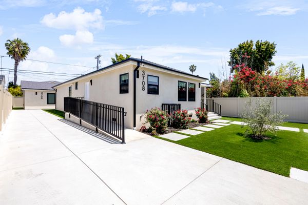 Modern single-story house with a wheelchair ramp and landscaped front yard.