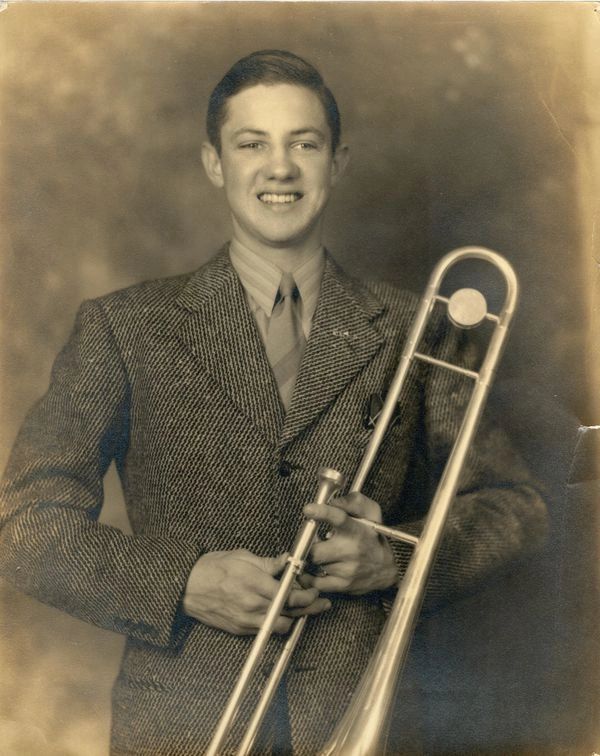 Smiling man holding a trombone.